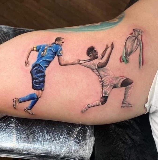 意大利球迷将基耶利尼拉倒萨卡的画面纹在手臂上，并配上足球回罗马的文字